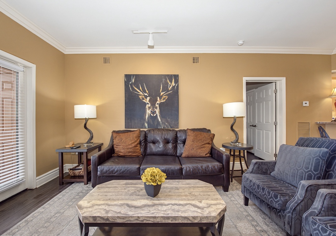 Settle into this sophisticated living room where rich leather seating and warm lighting create your perfect retreat for evening relaxation.