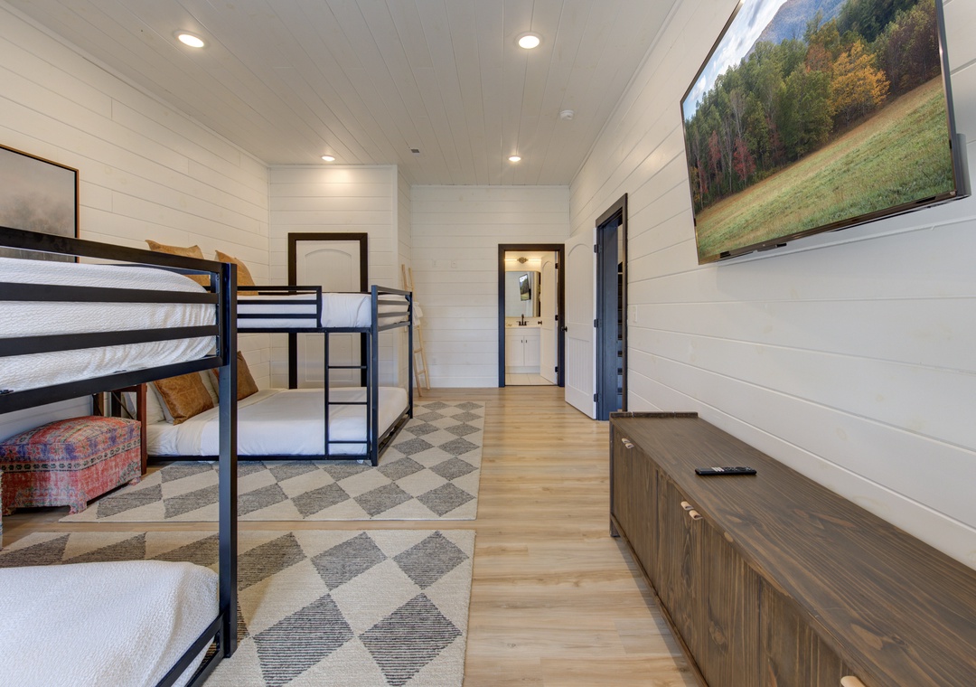 Your cozy bunk room features modern metal bunks with crisp linens, built-in storage, and a large TV for family movie nights.