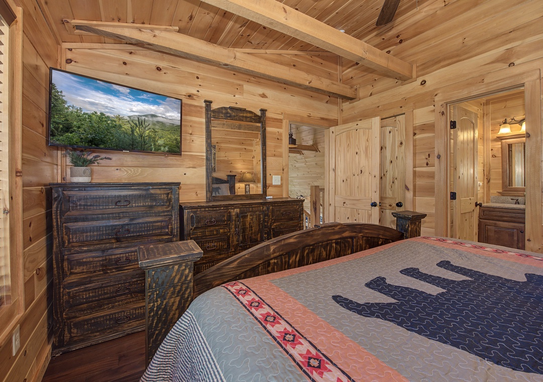 Your rustic-chic retreat features vaulted wood ceilings, handcrafted timber furniture, a wall-mounted TV for cozy evenings, and a private ensuite with ambient lighting.