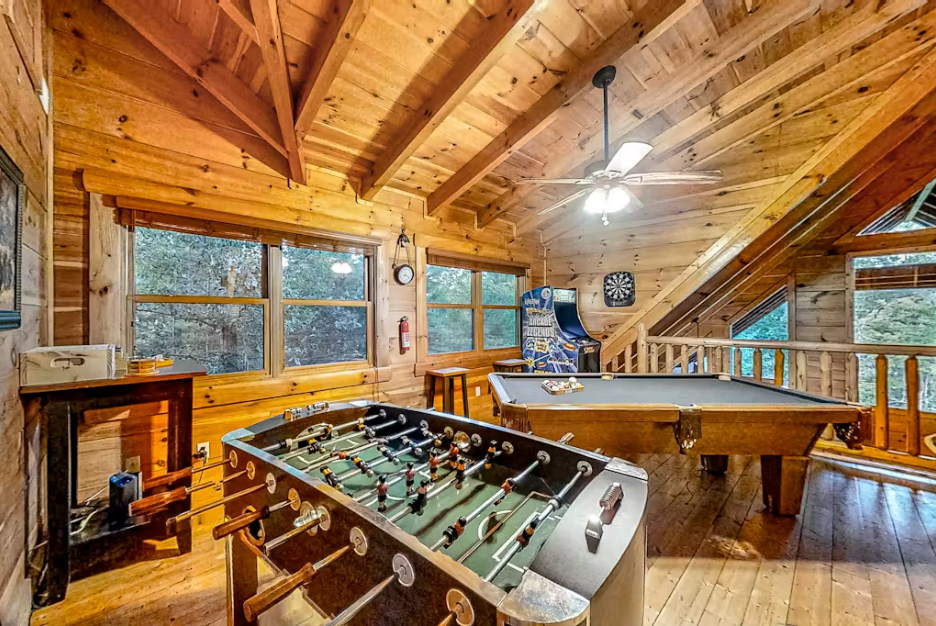 Your perfect game room retreat features foosball, pool, and darts surrounded by warm wood beams and forest views.