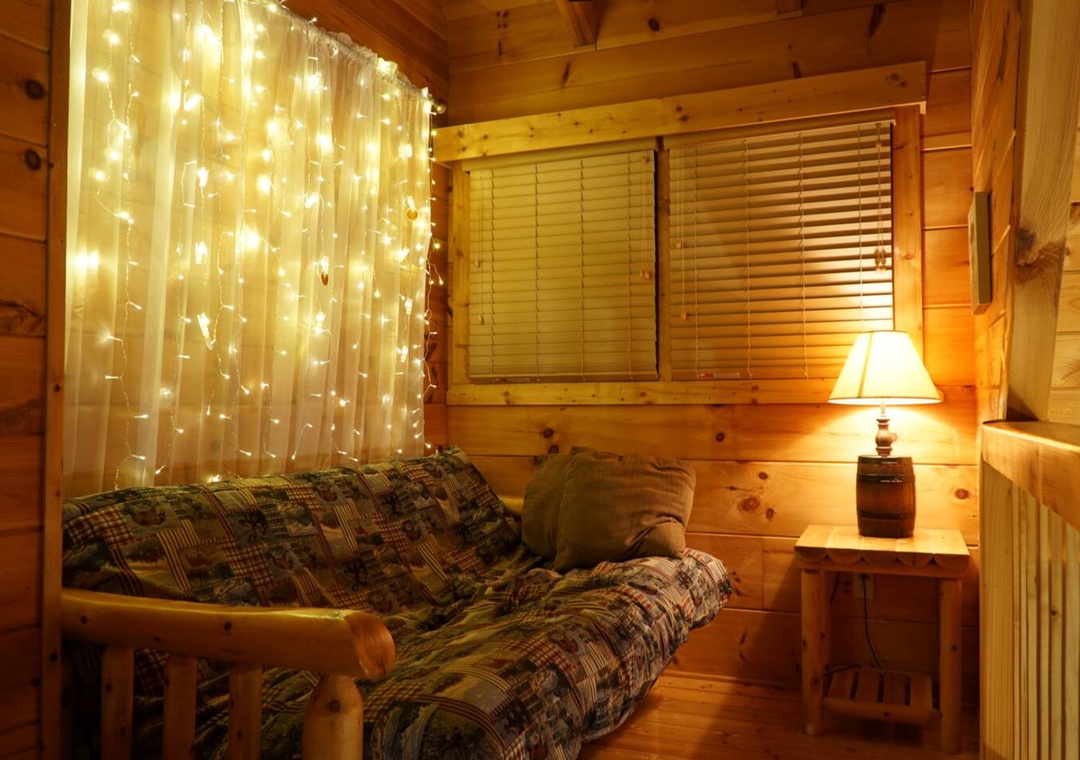 Unwind in your cozy cabin retreat with magical string lights creating the perfect ambiance for relaxing evenings.