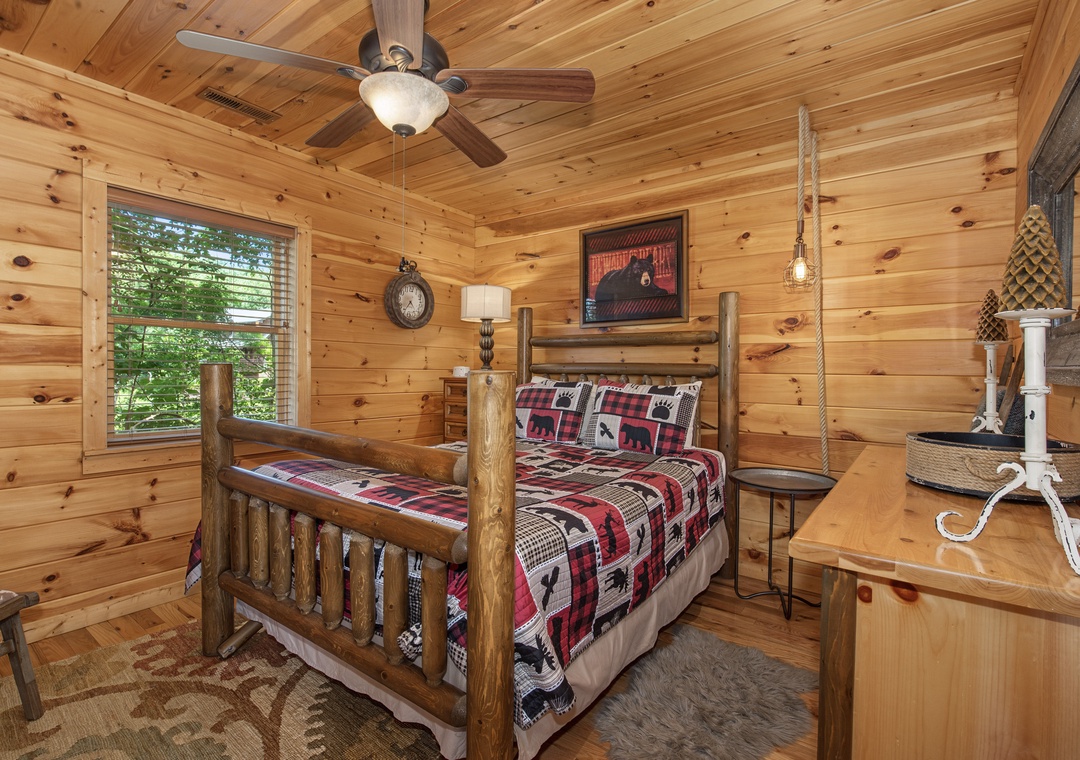 Drift off in your cozy cabin bedroom with handcrafted log furniture, warm knotty pine walls, and soft ceiling fan breeze—your peaceful mountain retreat awaits.