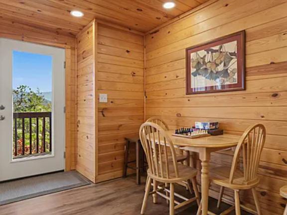 Step into your cozy cabin retreat where warm wood surrounds you. Enjoy morning coffee at your private dining nook, then step out to your balcony for stunning natural views.