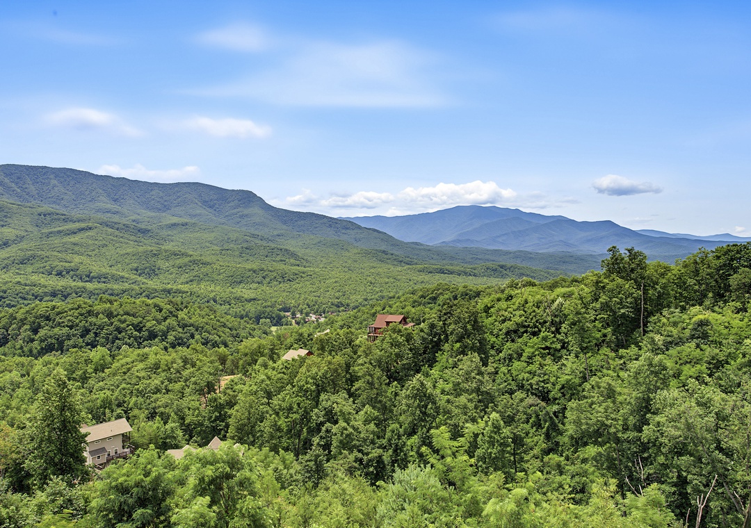Nestled in a lush mountain valley, this property offers stunning views of the surrounding peaks and forests. Cabins dot the tree-covered slopes, creating a peaceful retreat.
