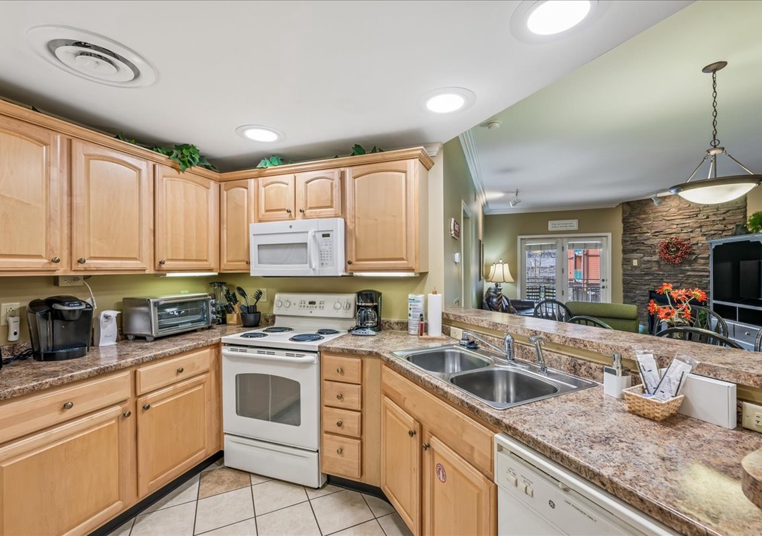 Your fully equipped kitchen features granite countertops, warm wood cabinets, and modern appliances for preparing delicious meals during your stay.