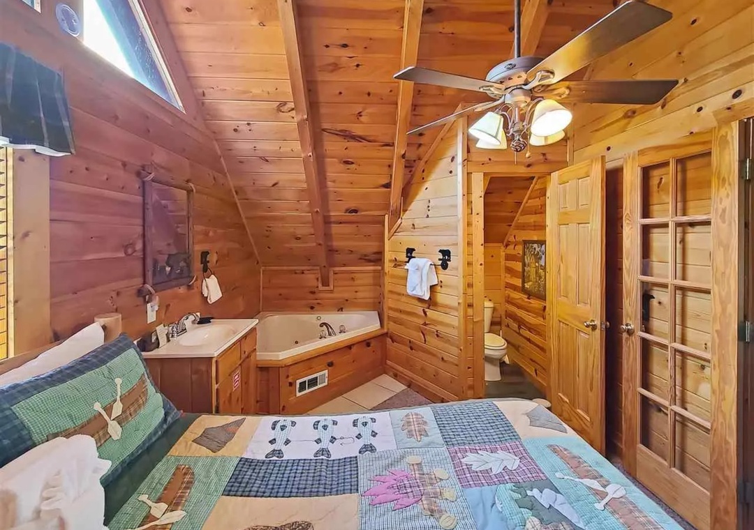 Unwind in your cozy log cabin suite featuring rustic wood walls, a relaxing jetted tub, and charming country quilts for ultimate comfort.