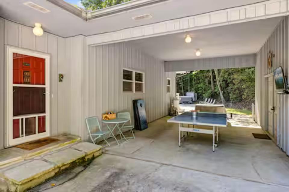 Your private garage doubles as a game room with ping pong table and seating, opening to your peaceful outdoor space.