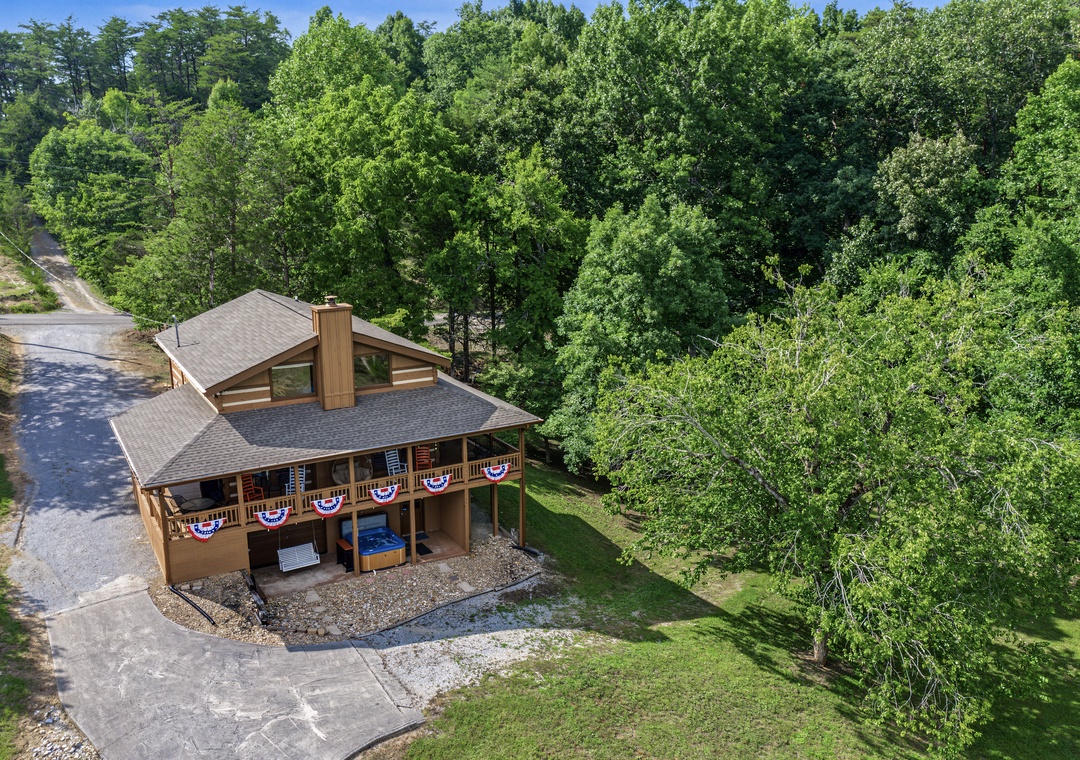 A charming mountain retreat nestled in lush wooded surroundings with festive touches, offering a private driveway and peaceful natural setting for a relaxing getaway.