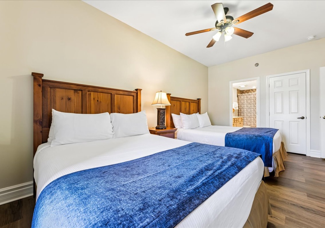 Unwind in your spacious bedroom with two plush beds, rich wood headboards, and gentle ceiling fan keeping you cool.