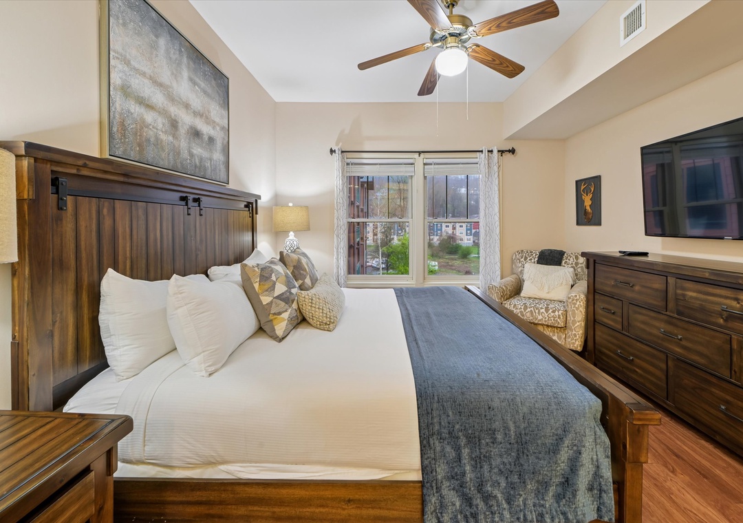 Rest deeply in your spacious bedroom with a cozy king bed, ceiling fan, flat-screen TV, and peaceful city views from your window.
