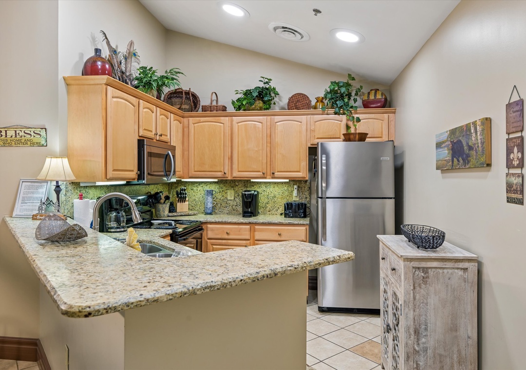 Prepare delicious meals in your fully equipped kitchen featuring granite counters, stainless appliances, and charming decorative touches.