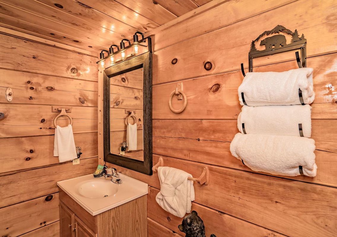 Warm wood-paneled bathroom with rustic charm, featuring fresh towels and forest-themed touches to make your mountain retreat feel like home.