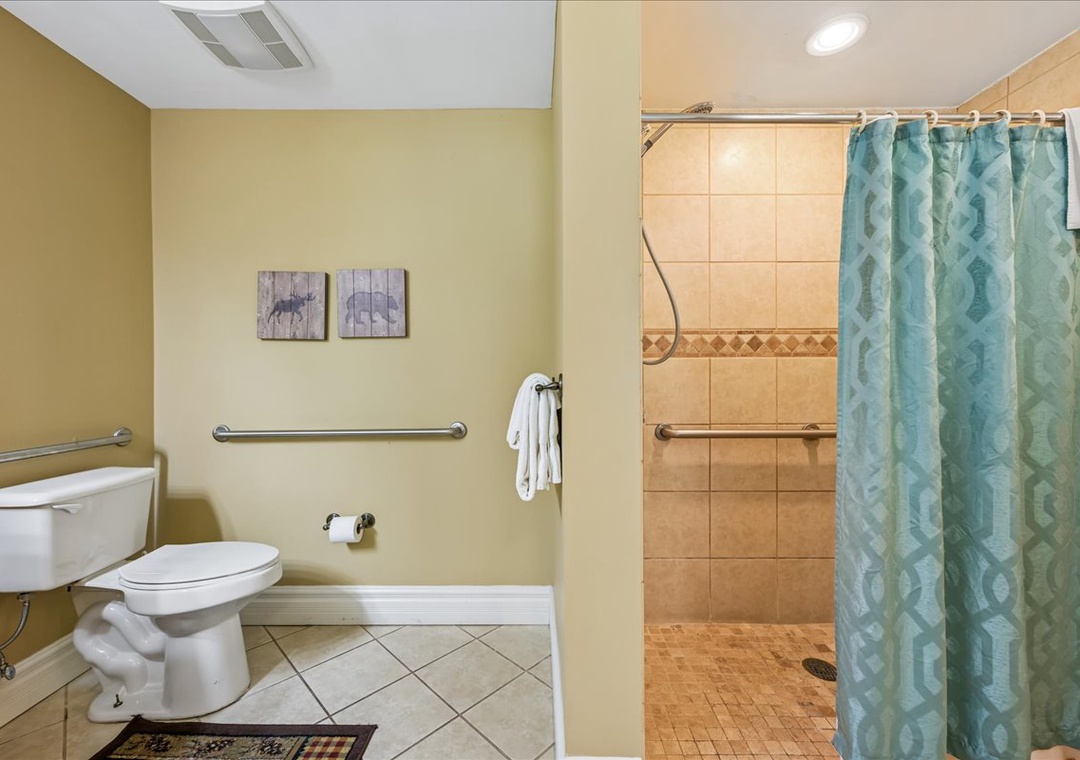 Your accessible bathroom features grab bars, a spacious walk-in shower, and thoughtful touches like fresh towels and charming artwork.