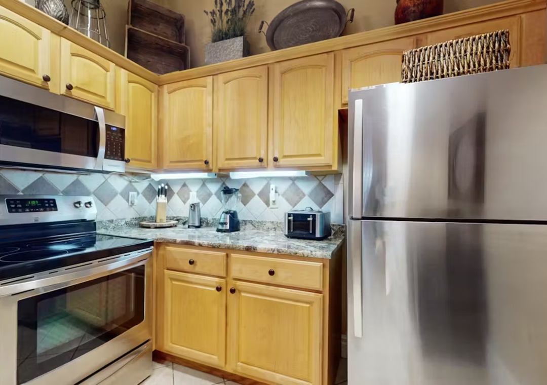 Your fully equipped kitchen features warm maple cabinets, granite counters, and stainless appliances for preparing memorable vacation meals together.