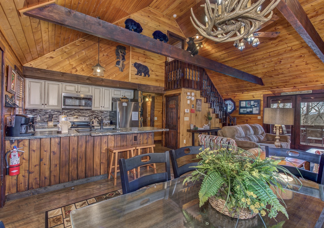 Step into your rustic retreat with soaring wood ceilings, antler chandelier, and open kitchen perfect for gathering around the dining table.