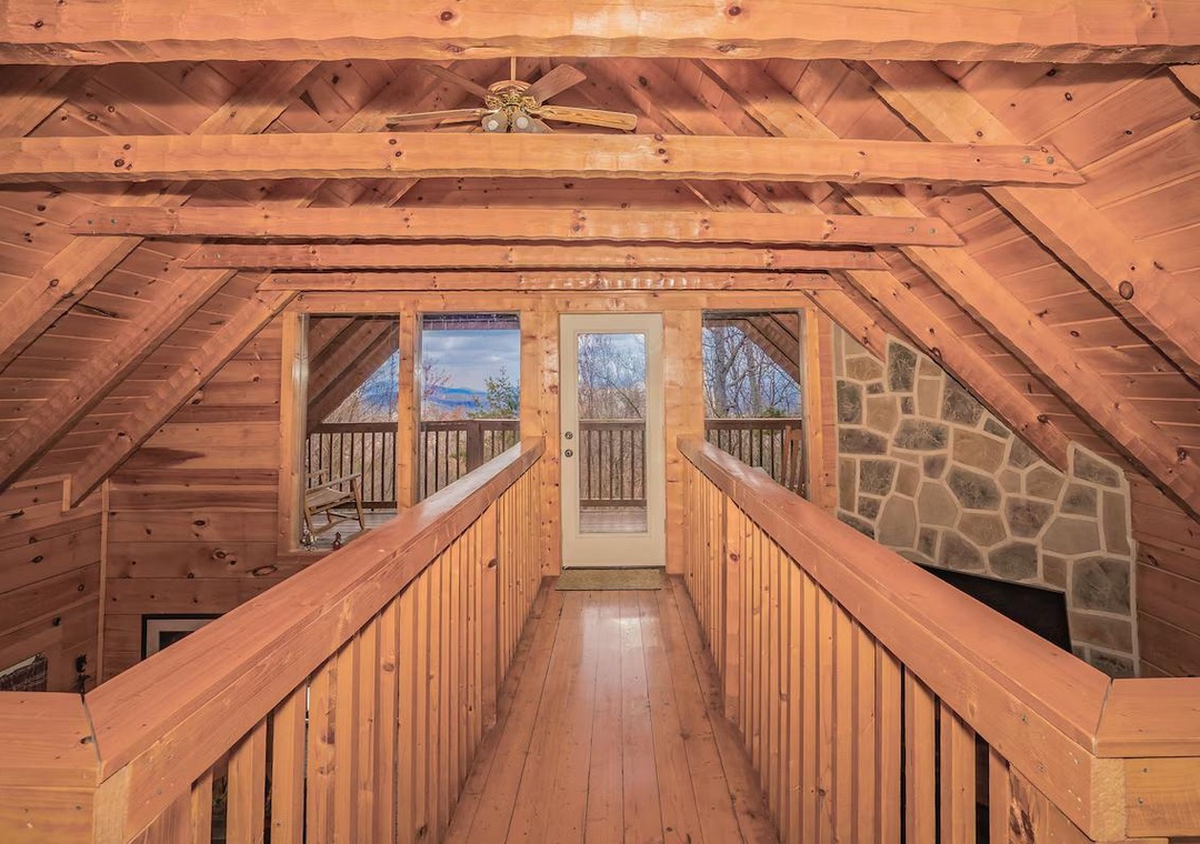 Step into this stunning loft area where warm wood surrounds you and natural light streams through glass doors leading to your private balcony.