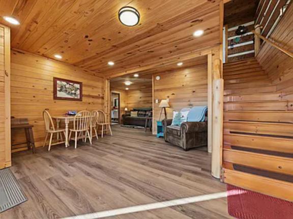 Warm wood-paneled walls embrace you as you step into this inviting open-concept space, complete with a cozy dining table and comfortable living area—perfect for gathering after a day of adventure.