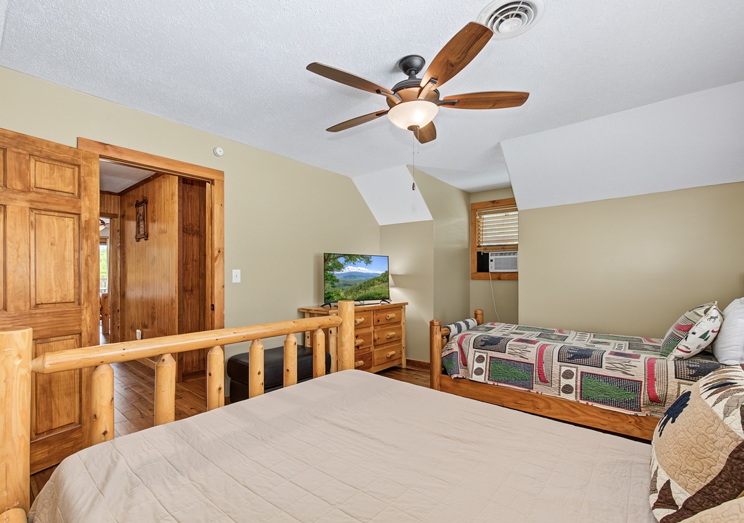 Relax in your cozy bedroom with rustic wood furnishings and a ceiling fan to keep you cool. Unwind watching TV or gazing at mountain views through the window.