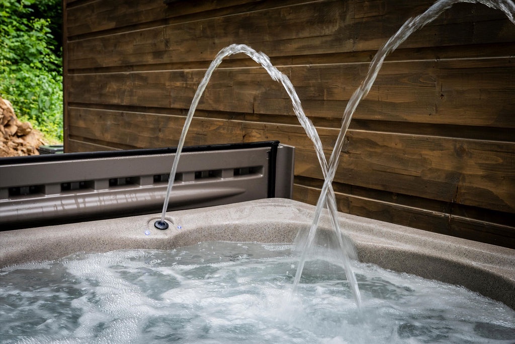 Slip into your private hot tub, where dual water jets create a soothing fountain as warm bubbles melt away the day. Surrounded by natural wood and greenery, pure relaxation awaits.