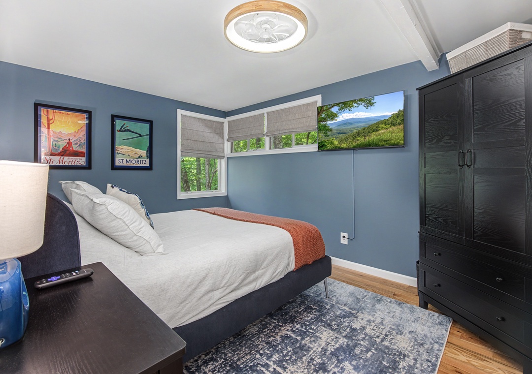 Drift into peaceful sleep in your serene bedroom, framed by windows overlooking lush greenery and mountain views that greet you each morning with nature's beauty.