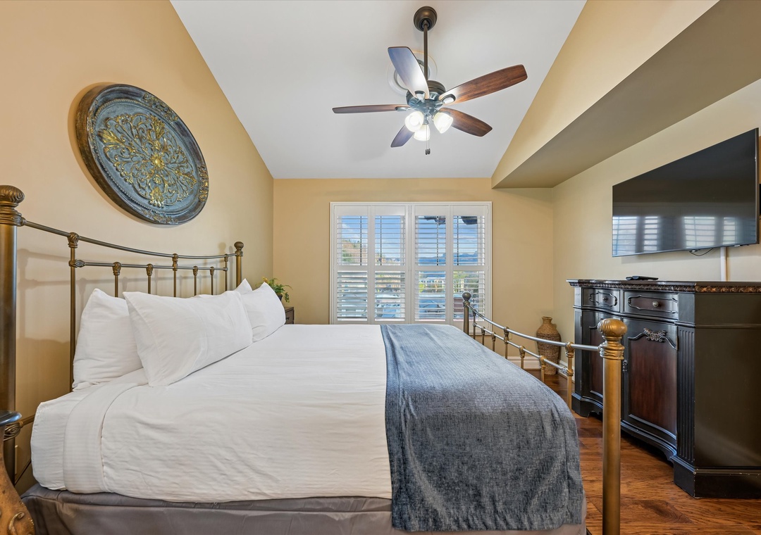 Rest peacefully in your elegant brass bed beneath the gentle ceiling fan, with rich hardwood floors and entertainment center completing your cozy retreat.