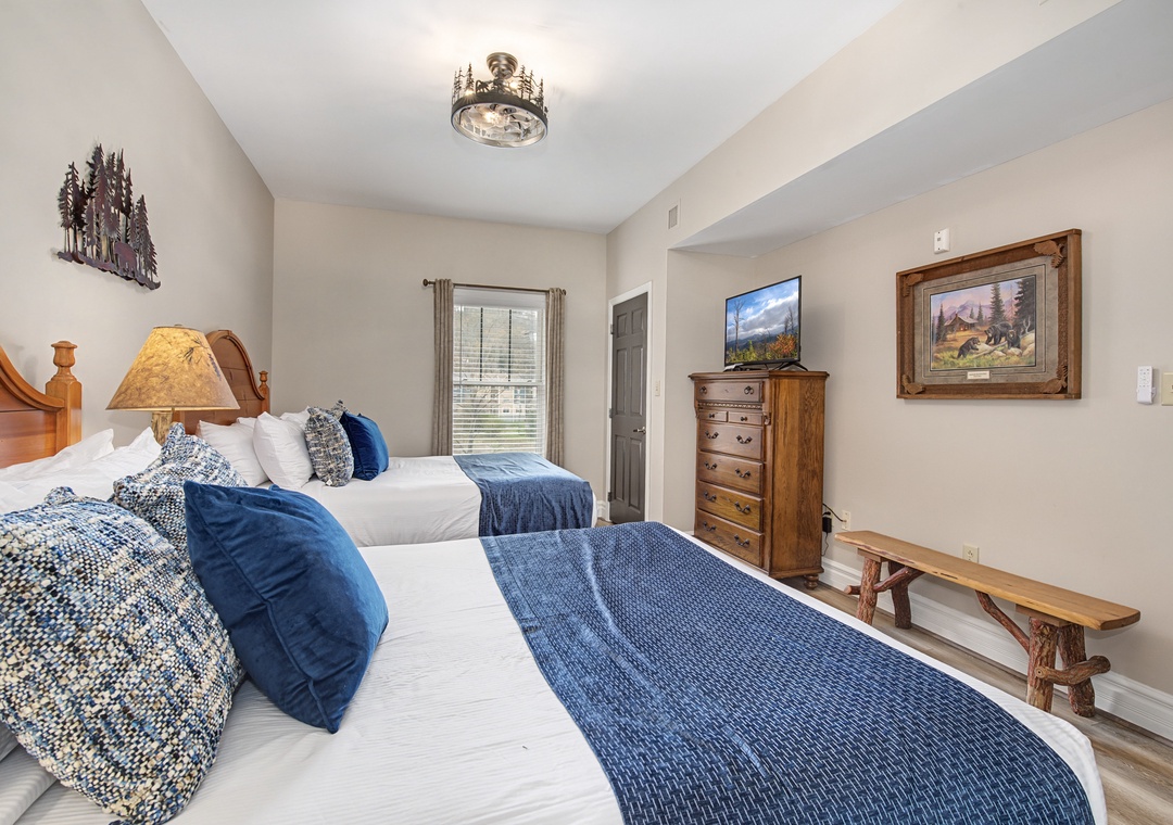 Sink into crisp white linens and navy accents in your cozy twin bedroom, complete with rustic charm and mountain artwork.
