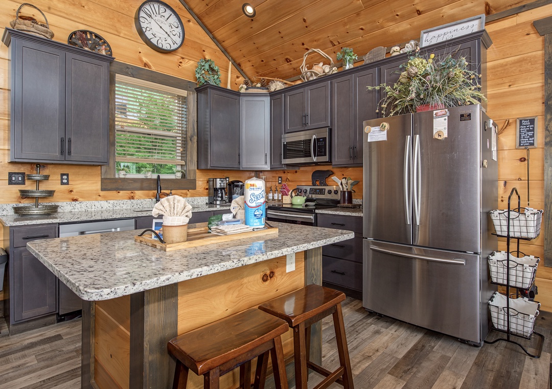 Your fully equipped kitchen invites you to prepare meals with modern appliances, granite countertops, and a cozy island with seating—all wrapped in warm wood and rustic charm.