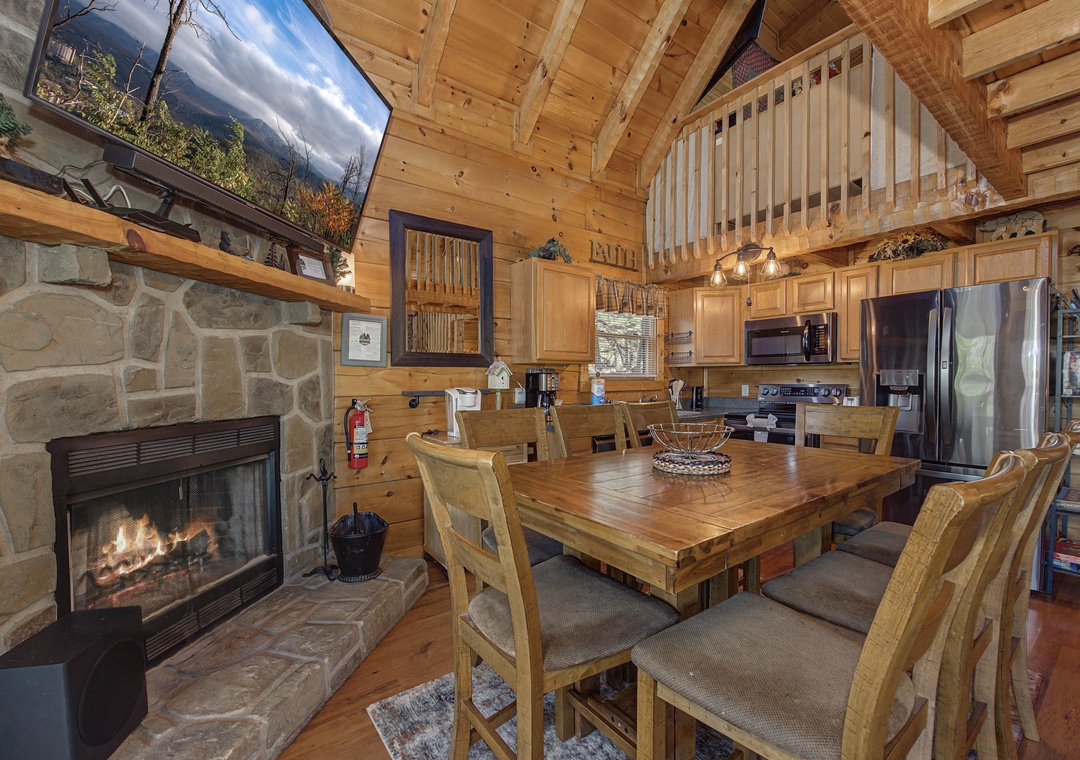 Your cozy cabin retreat features rustic wood beams, a crackling stone fireplace, and a welcoming dining space perfect for gathering.