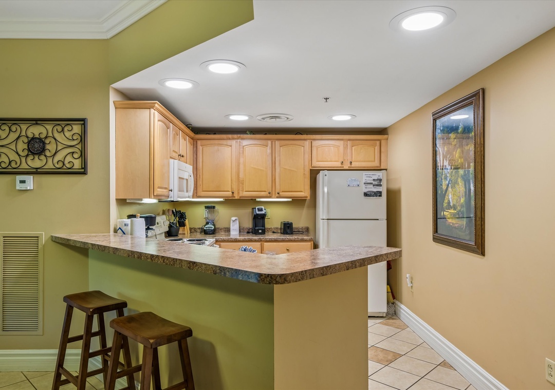 Your fully equipped kitchen features granite counters, modern appliances, and a breakfast bar perfect for morning coffee or casual dining together.