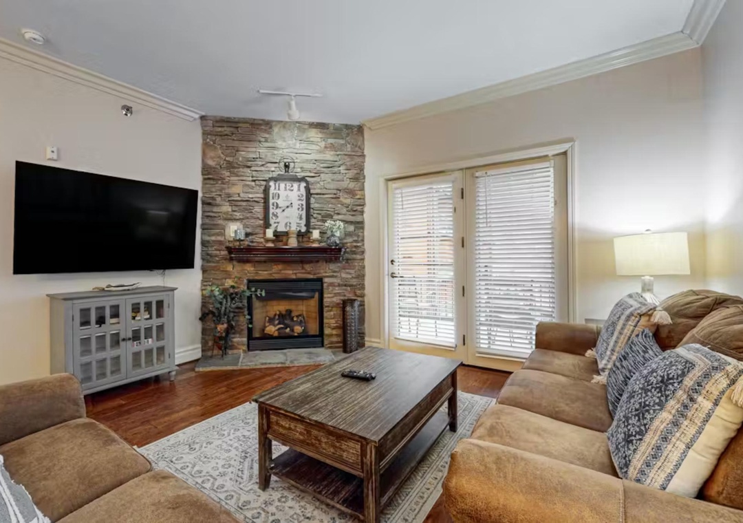 Sink into plush seating by your stone fireplace, where warmth meets modern comfort in this inviting living space.