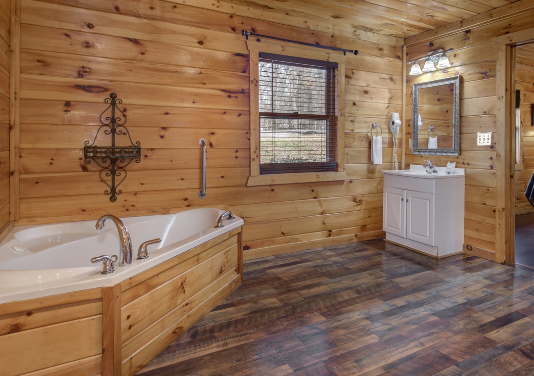 Soak in your private jacuzzi tub surrounded by warm cedar walls and rustic charm in this spacious log cabin bathroom.