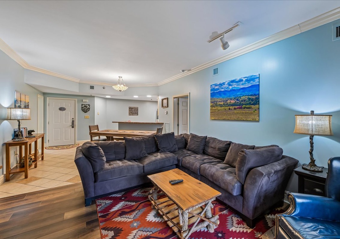 Sink into your spacious sectional sofa and unwind in this bright, welcoming living space with soothing blue walls and charming mountain artwork.