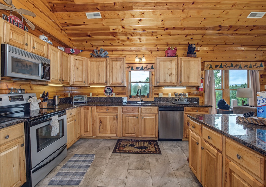 Picture yourself whipping up breakfast in this fully-equipped cabin kitchen, warmed by natural wood and granite counters, with mountain views framing your morning coffee.