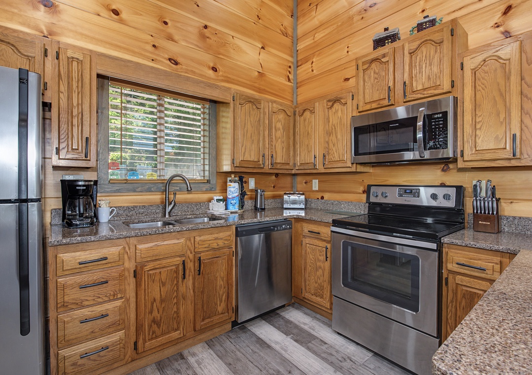 Your fully equipped kitchen features stainless steel appliances, granite countertops, and warm wood cabinetry—perfect for preparing family meals or morning coffee with natural light streaming in.