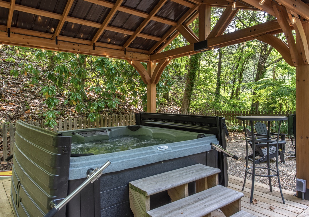 Slip into your private hot tub under a timber pavilion, surrounded by wooded tranquility—your perfect spot to unwind after a day of exploring.