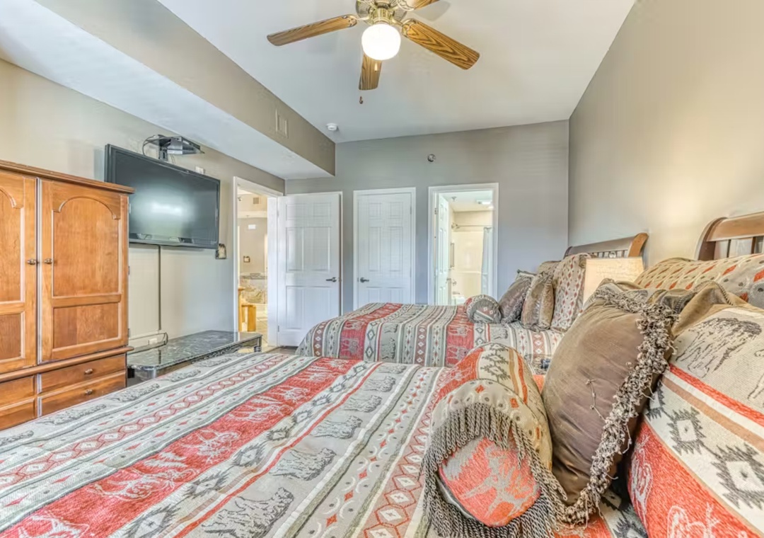 Drift off to sleep on cozy patterned bedding while gentle ceiling fan breezes keep you comfortable in this spacious master bedroom.