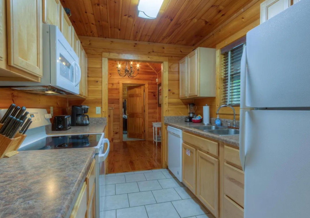 Step into your fully equipped kitchen, where warm wood tones and modern appliances create the perfect space for preparing homemade meals during your mountain getaway.
