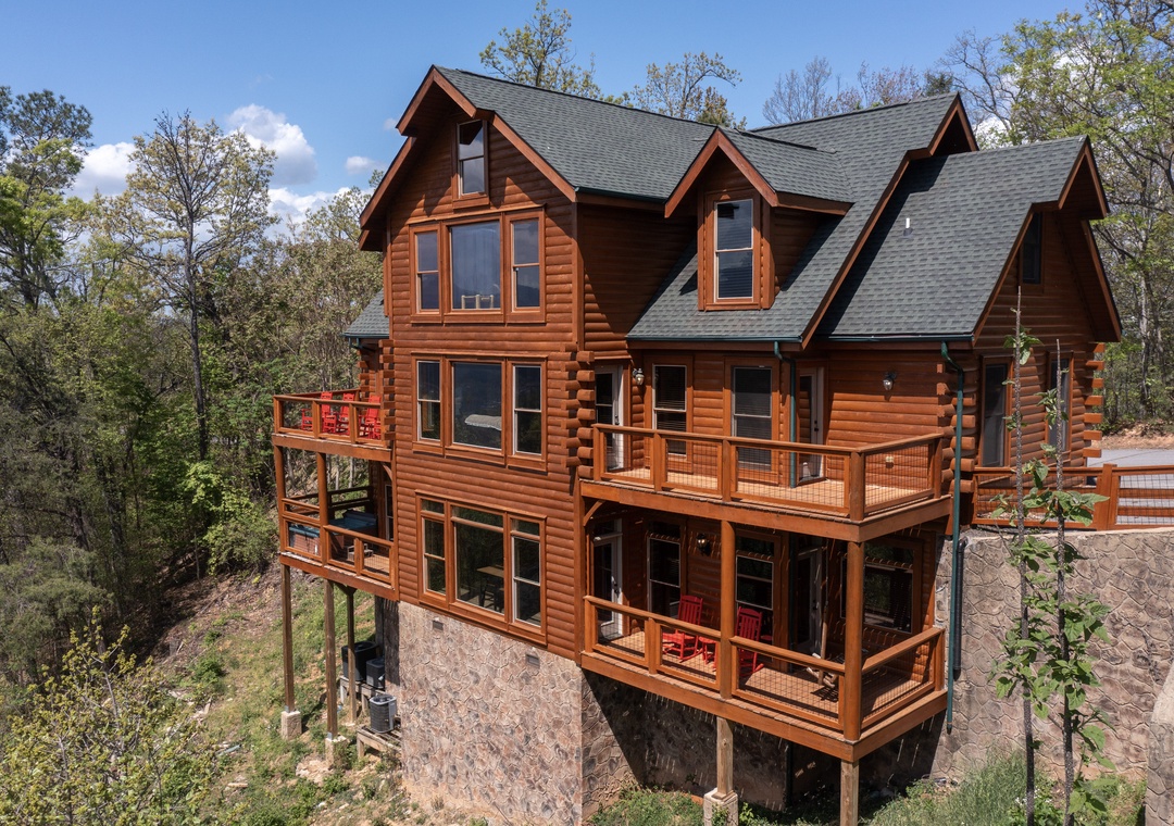 A stunning log cabin retreat nestled among towering trees, featuring spacious decks and rustic charm in a peaceful wooded setting.