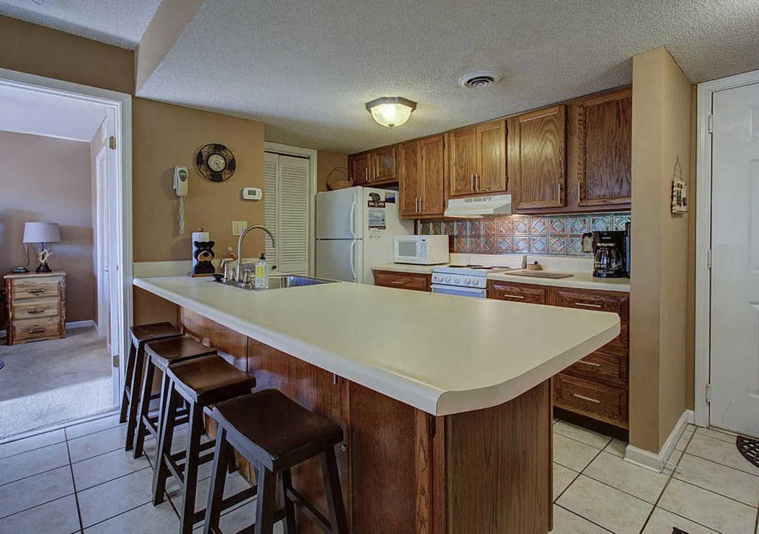 Your spacious kitchen offers everything needed for home-cooked meals, featuring warm wood cabinets, modern appliances, and a breakfast bar for casual dining.