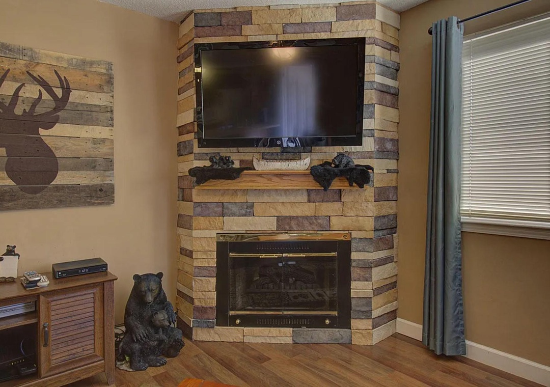 Cozy up by your stone fireplace while watching the large TV - rustic cabin charm meets modern comfort in your living space.