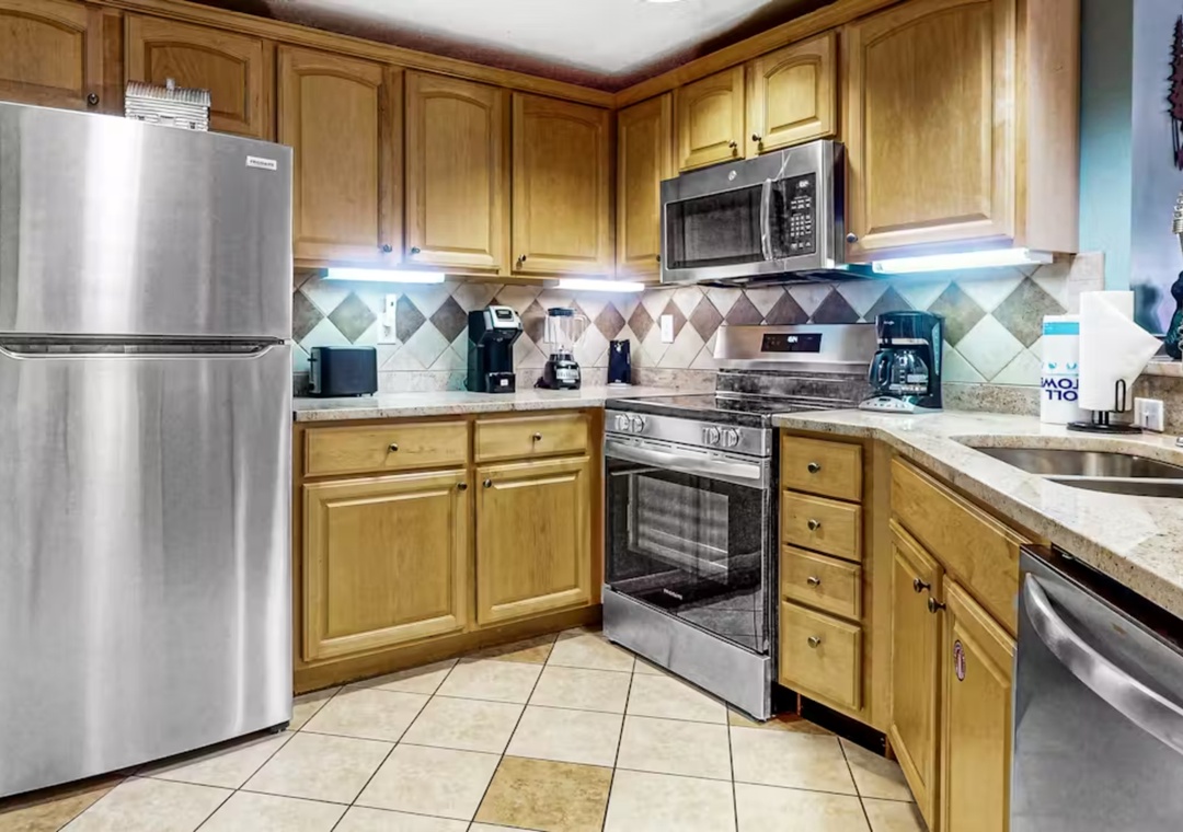 Your fully equipped kitchen features stainless steel appliances, granite countertops, and warm wood cabinets—perfect for preparing your favorite meals.