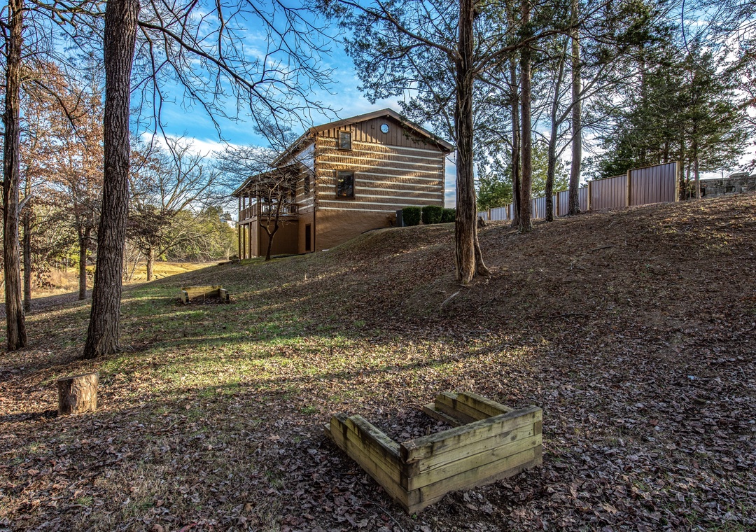 Rustic log cabin nestled among towering trees on a gentle hillside, surrounded by natural landscape and wooded serenity.