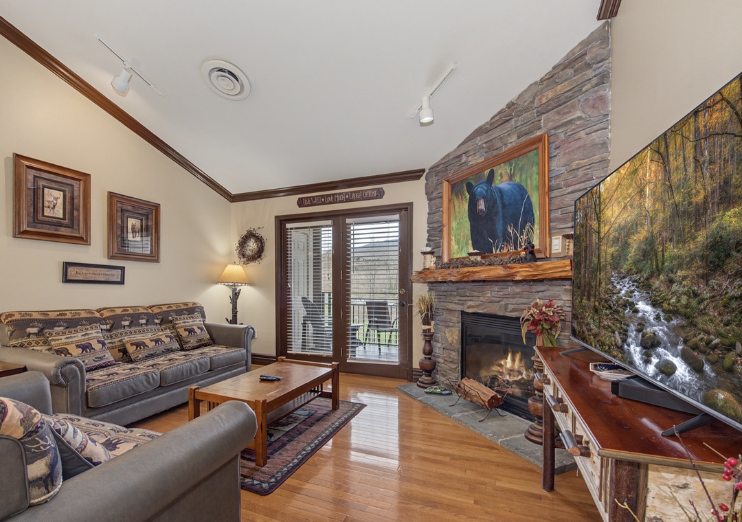 Gather around the crackling stone fireplace in this cozy living room, where rustic charm meets mountain comfort for perfect evenings.