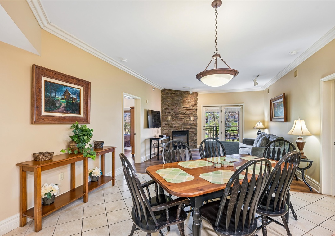 Gather around this inviting dining table for family meals, with your cozy living area and stone fireplace creating the perfect backdrop.