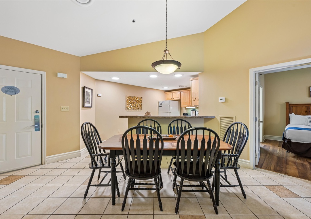 Gather around your spacious dining table for six, where warm golden walls and elegant pendant lighting create the perfect atmosphere for memorable meals together.