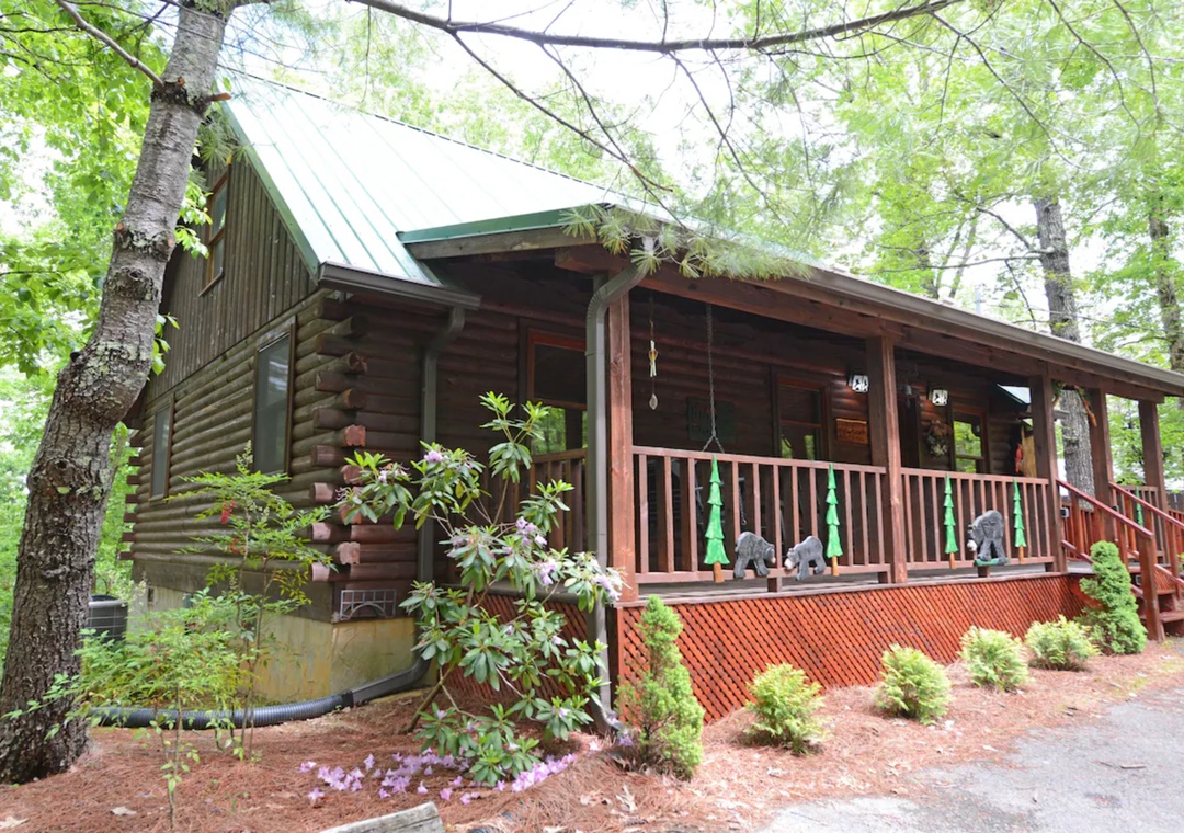 Rustic log cabin nestled among towering trees offers your perfect woodland retreat with charming covered porch and peaceful natural surroundings.