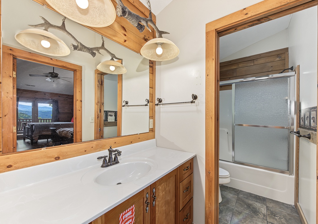 Your private bathroom blends rustic charm with modern comfort—wooden accents, charming fish décor, and a refreshing shower await after a day exploring the mountains.