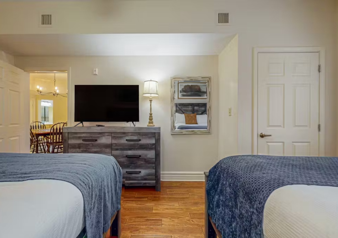 Relax in your spacious bedroom with twin beds, modern TV, and charming decor that creates the perfect retreat for restful nights.