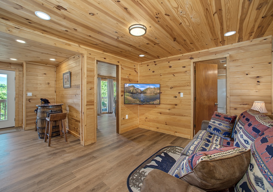 Wrap yourself in the warmth of natural wood as you sink into the cozy couch. Through the windows, lush greenery beckons, inviting you to step outside or simply relax and enjoy your peaceful retreat.