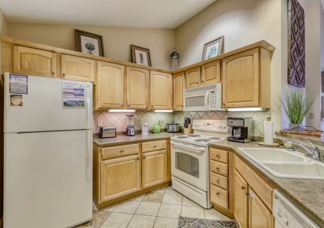 Your fully equipped kitchen awaits with warm wood cabinets, granite counters, and everything you need to create memorable meals during your stay.